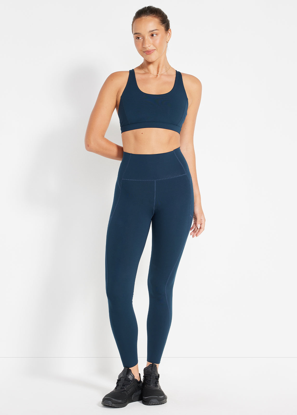 Model wearing navy scoop bra and high-rise leggings designed for movement