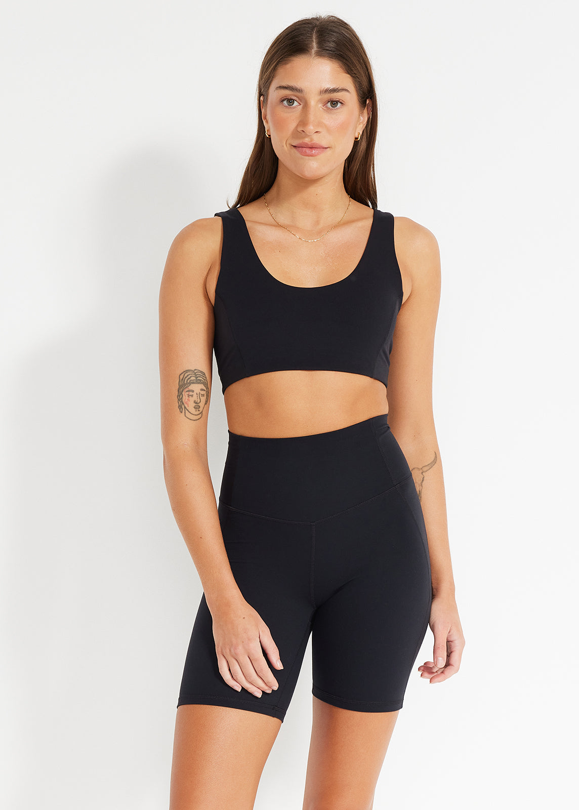 Model wearing black scoop crop and high-rise bike shorts designed for active comfort