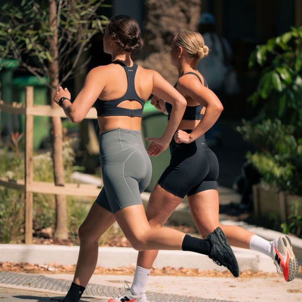 Two women sprinting outdoors in Nimble In Pace running sets.